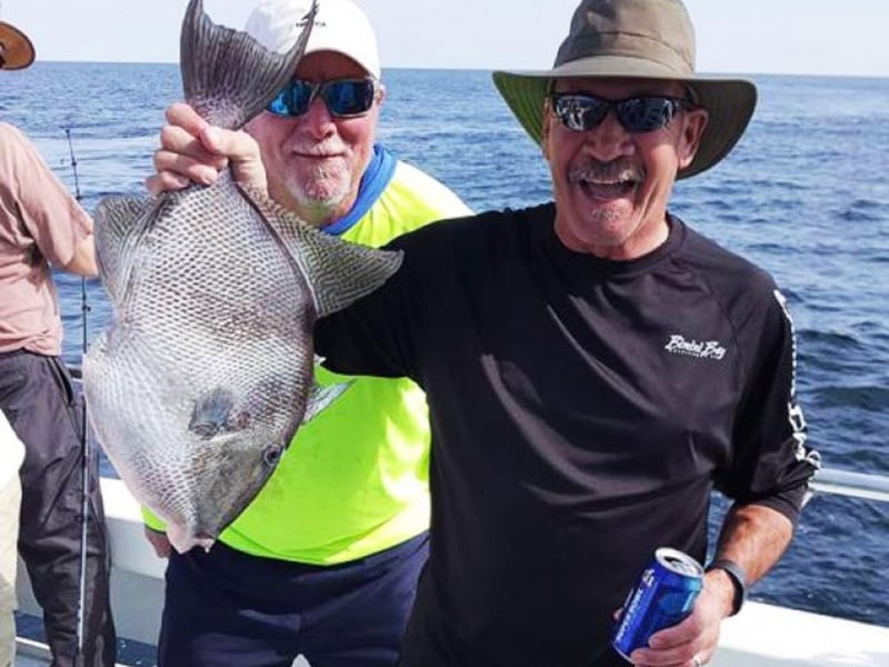 An angler showing off his catch on board Hey Babe