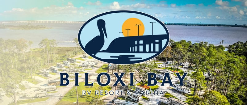 Aerial view of a waterfront RV resort and marina along Biloxi Bay with campsites, trees, and open water in the background with resort logo overlay.