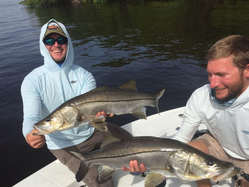 Two anglers showing off their catches