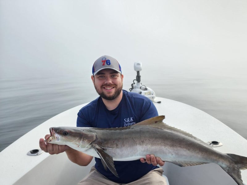 An angler showing off his catch on the boat