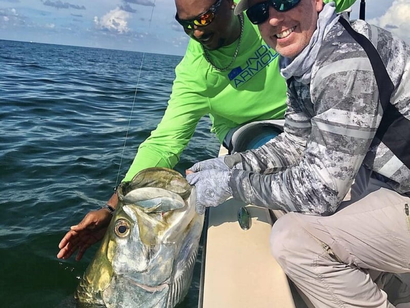 Two guests fishing off the side of the boat