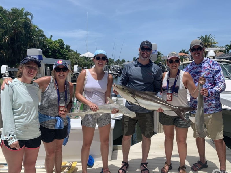 A group showing off their catches on the dock