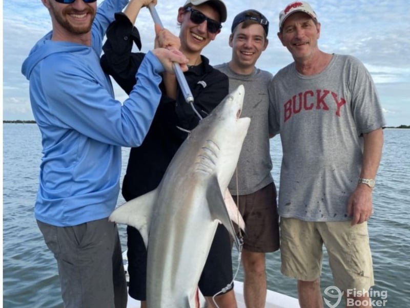 A group showing off their shark with Red Snarpon Charters Inc.