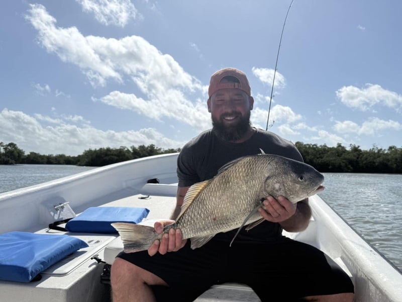 A man showing off his fish on the boat
