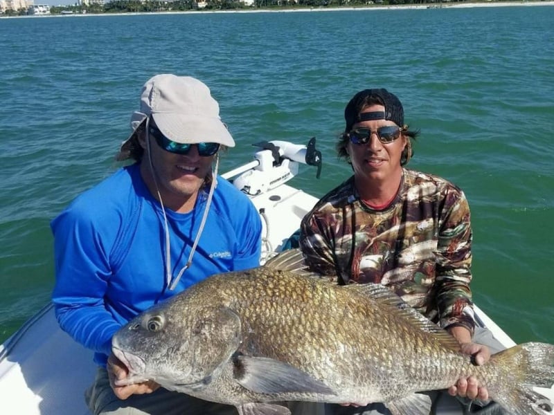 Anglers with their fish on the back of the boat