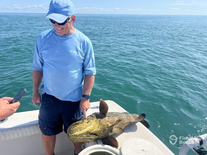 A guest on the back of the boat with his large fish