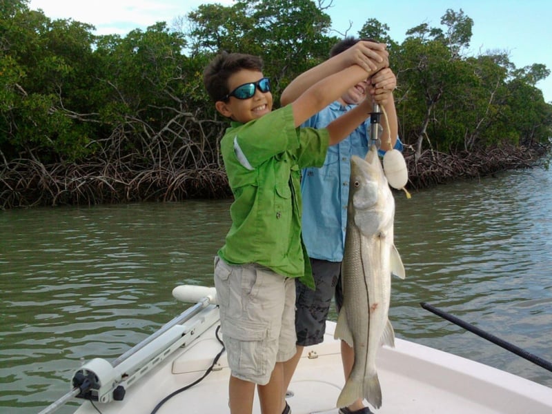 A kid with his catch on the boat in Marco Island, Florida