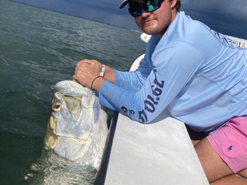 A man fishing off the side of the boat