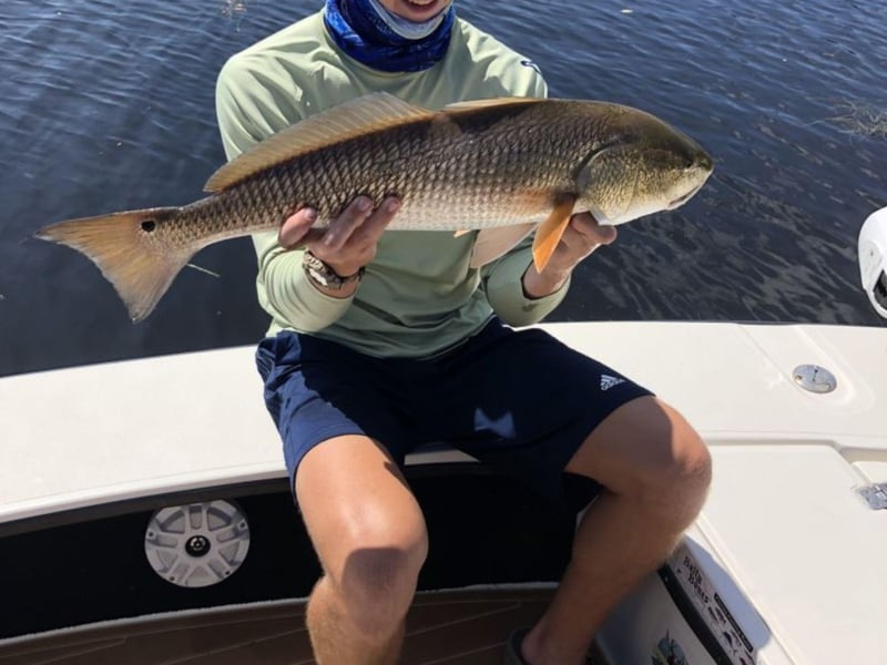 An angler showing off his catch on the boat