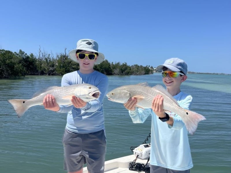 Two kids showing off their catches