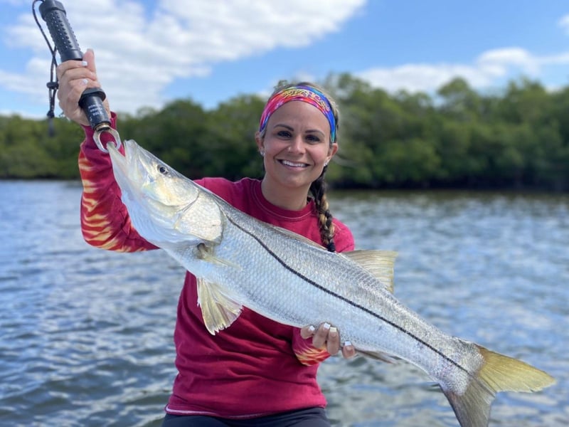 An angler showing off her catch on the boat