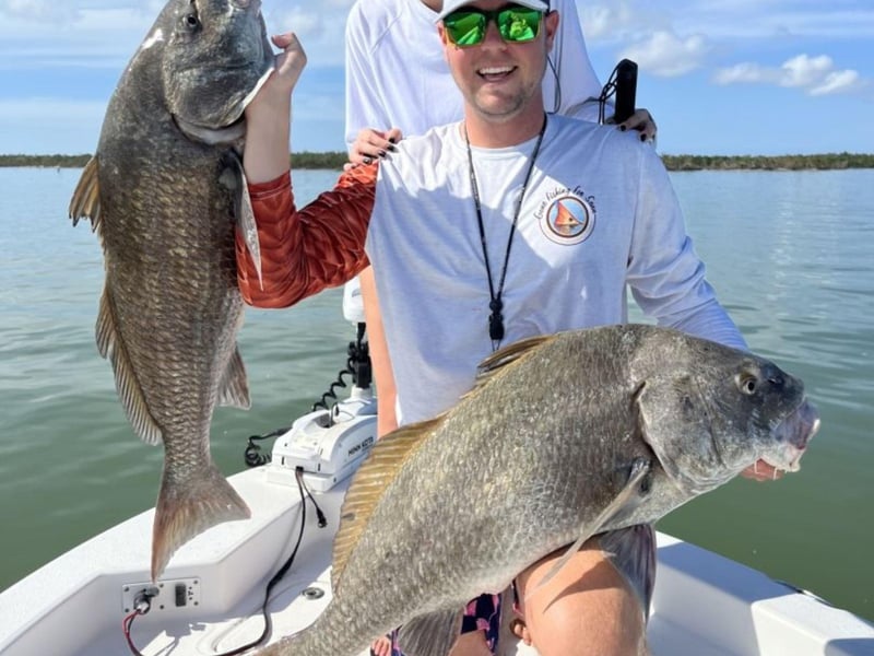Two anglers showing off their catches