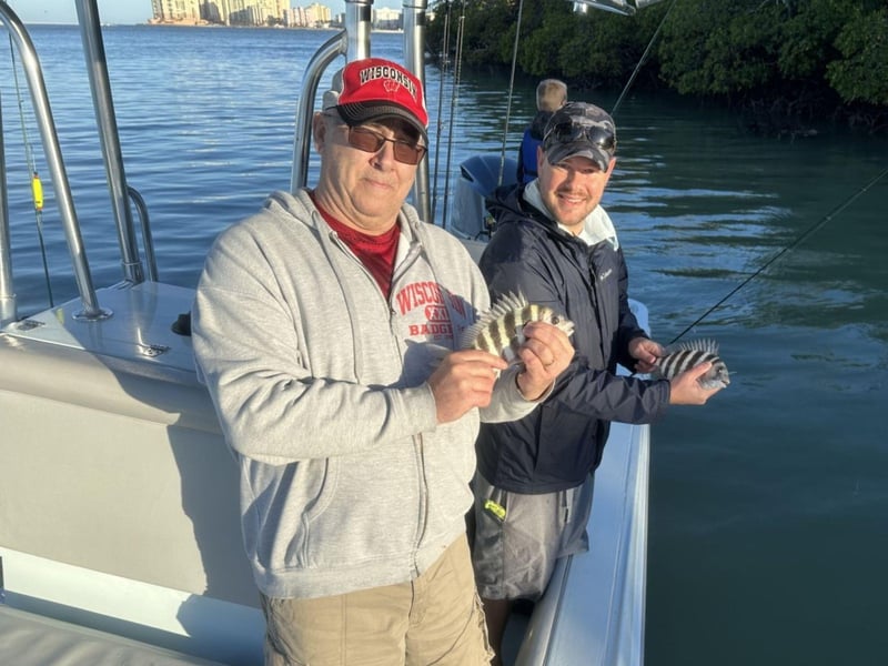 Two anglers showing off their catches