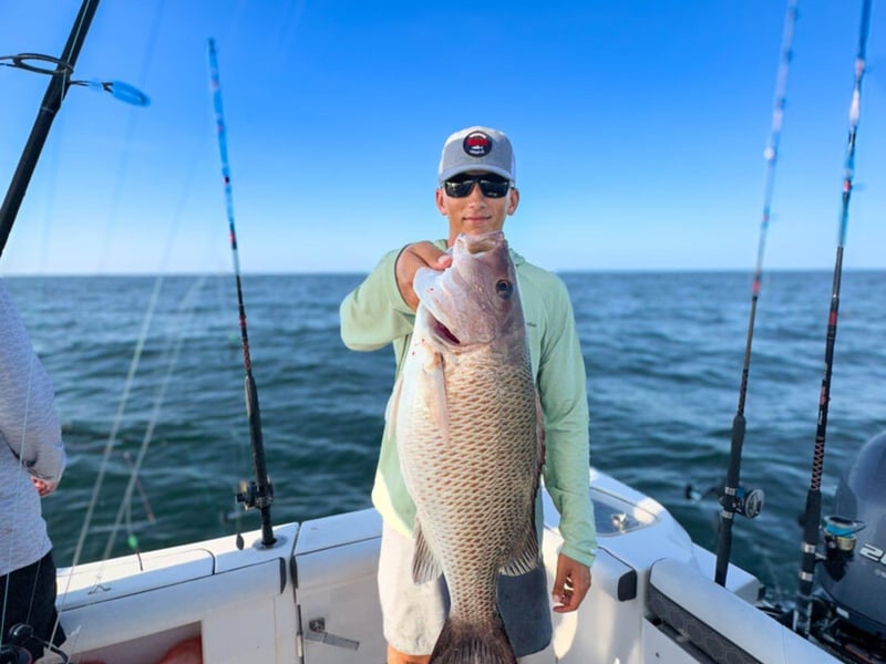 A guest showing off his large catch on the boat