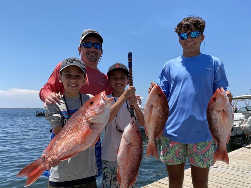 A family showing off their Red Snapper