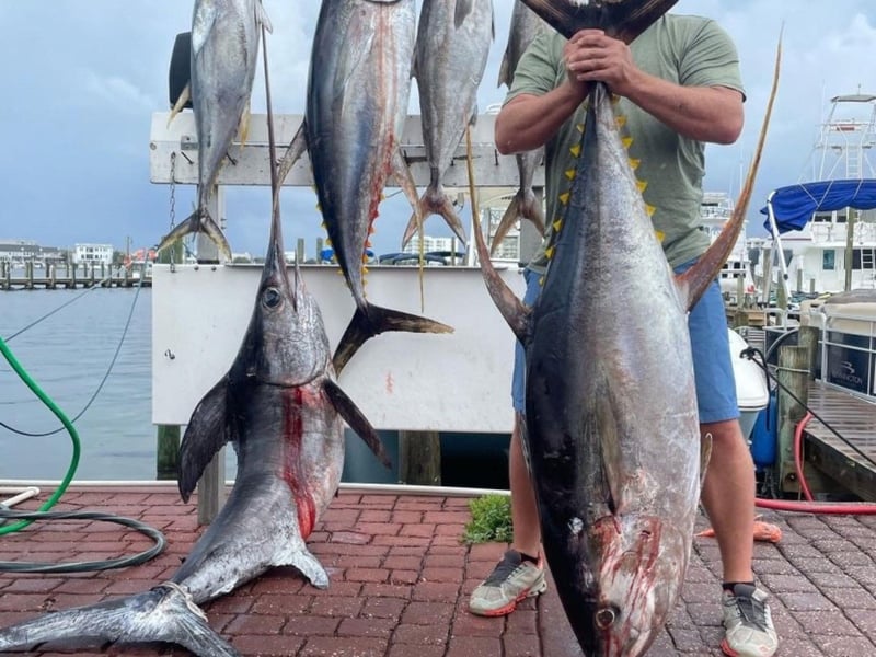 An angler showing off his catches at the dock