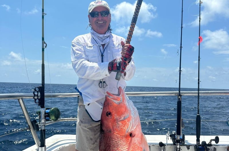 A man showing off his catch on the back of Swoop II in Destin, Florida