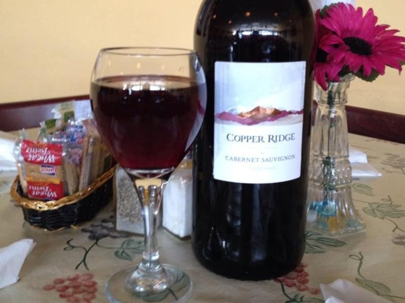 A wine glass and bottle from Petrellas Italian Cafe in Pensacola, Florida