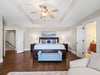 Bedroom 1 Relax in spacious featuring a king bed, elegant tray ceiling, and comfortable seating area for the perfect retreat.