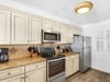 Fully equipped kitchen features cream cabinetry, granite countertops, and stainless steel appliances for all your cooking needs.
