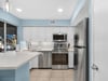 Your bright modern kitchen features stainless steel appliances, crisp white cabinets, and calming blue walls that create a cheerful cooking space.