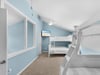 Your kids will love this cheerful bunk room with oceanblue walls and crisp white beds, complete with entertainment for cozy evenings.