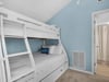 Cozy bunk room with crisp white linens and soothing blue walls creates your perfect beach retreat sleeping space.