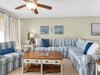 Sink into the plush striped sectional sofa where coastal artwork and soft blues create your perfect seaside retreat.