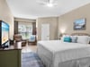 Unwind in your spacious bedroom with plush bedding, cozy seating area, and peaceful garden views through large windows.