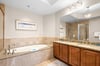 Ensuite bathroom with a deep soaking tub, granite countertops, and elegant fixtures designed for ultimate relaxation.