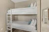 Cozy bunk beds with crisp white linens and cheerful blue accents create the perfect space for your familys comfort.