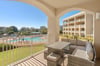 Relax on the private balcony with wicker seating while enjoying views of the sparkling pool and lush resort grounds.