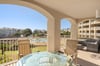 Spacious covered balcony with pool views and comfortable seating for dining and lounging.