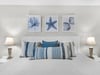 Bedroom 1 with crisp white linens and coastalinspired pillows, while oceanthemed artwork creates your peaceful seaside retreat.