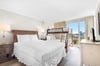 Relax in your bright bedroom featuring a cozy main bed and convenient bunk bed, with city views streaming through large windows.