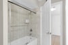 Step into your elegant bathroom featuring a spacious tubshower combo with marblelook tile and convenient grab bar for comfort.