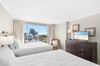 Wake up in your bright, comfortable bedroom with two plush beds and stunning city views through floortoceiling windows.