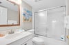 Step into your pristine bathroom with sparkling white fixtures and a spacious glassenclosed shower perfect for refreshing after beach days.