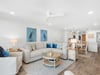 Relax in your bright, coastalinspired living space featuring plush sectional seating, charming heron artwork, and an open layout flowing into the dining area.