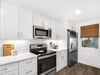 Your bright, fullyequipped kitchen features crisp white cabinetry and stainless steel appliances, ready for homecooked meals.
