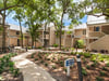 A peaceful property nestled among mature trees, with pathways and landscaping connecting separate buildings.