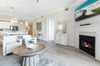Unwind in your spacious openconcept living area, complete with a cozy fireplace, modern kitchen, and coastal décor that invites relaxation and memorable gatherings.