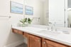 Refresh in your bright, stylish bathroom with coastalinspired art, warm wood accents, and a pristine vanity designed for your comfort.