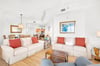 Sink into plush seating where natural textures and pops of coral invite you to unwind after sunsoaked beach days.