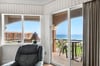 The balcony opens to coastal breezes, perfect for morning coffee or evening relaxation.