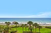Vibrant beachfront setting with palmlined grounds, white sandy shores, and crystalclear waters stretching to the horizon.