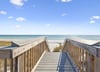 Private boardwalk leads directly to pristine white sand beach and crystalclear turquoise waters under sunny skies, offering easy access to your coastal escape.
