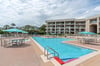 The sparkling outdoor pool is surrounded by comfortable lounge seating and shaded umbrellas, perfect for a refreshing swim or relaxing poolside with a good book.
