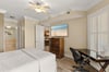 Peaceful king bedroom retreat features a plush bed, ceiling fan for comfort, and elegant coastal artwork that sets the tone for your relaxing getaway.