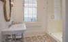 A pedestal sink, and white subway tiled shower is offered for the fourth suite.